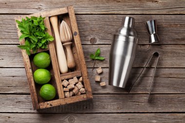 Mojito kokteyl malzemeler kutusu ve bar aksesuarları tahta masada. Üstten görünüm