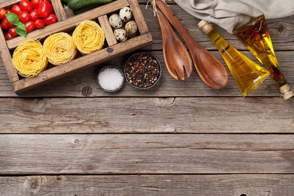 Pasta and ingredients. Tomatoes, basil, cucumbers and spices. Cooking concept. Top view with copy space 