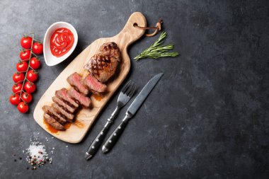 Dilimlenmiş dana biftek kesme tahtası üzerinde Taş Masa üzerinde ızgara. Kopya alanı ile Üstten Görünüm