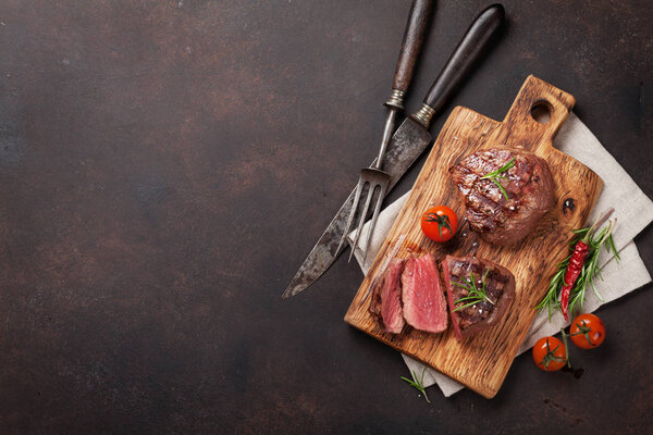 Grilled fillet steaks on cutting board. Top view with space for your text