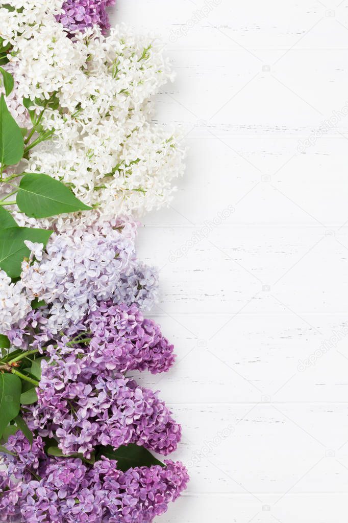 Colorful lilac flowers over wooden background. Top view with space for your text