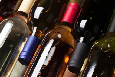 Kırmızı, gül ve beyaz şarap şişeleri taş masada. Üstten görünüm