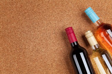 Ahşap masa üzerinde şarap şişeleri. Kırmızı, gül ve beyaz şarap. Metin alanı olan üstten görünüm