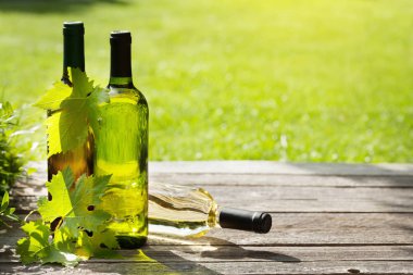 Ahşap masa üzerinde beyaz şarap şişeleri. Açık natürmort. Senin metin için ile yer