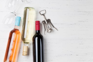 Ahşap masa üzerinde şarap şişeleri. Kırmızı, gül ve beyaz şarap. Metin alanı olan üstten görünüm