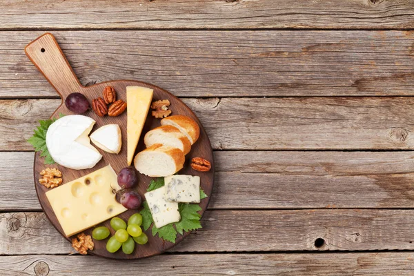 奶酪板上有葡萄和坚果 酒类小吃 带空格的顶部视图 — 图库照片