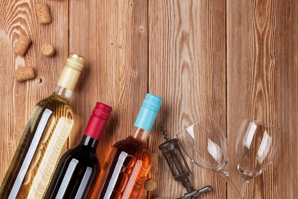 Ahşap masa üzerinde şarap şişeleri. Kırmızı, gül ve beyaz şarap. Metin alanı olan üstten görünüm