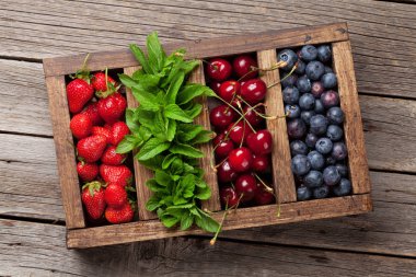 Taze yaz meyveleri kutusu. Kiraz, böğürtlen ve çilek ve nane. Üstten görünüm