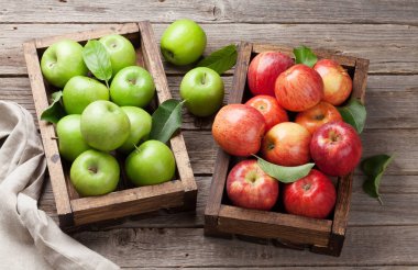 Ripe green and red apples in wooden box clipart