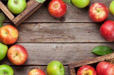 Olgun yeşil ve kırmızı elma ahşap masa üzerinde. Metin alanı olan üstten görünüm