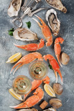 Deniz ürünleri. İstiridye, ıstakoz, istiridye ve beyaz şarap. Taş masada Üstten Görünüm