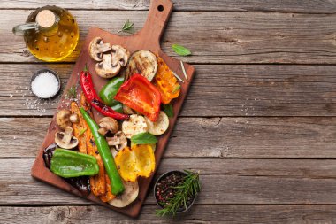 Kesme tahtası ahşap masa üzerinde ızgara sebze. Kopya alanı ile üstten görünüm