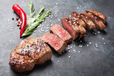 Tuz, biber ve biberiye taş tablo ile dilimlenmiş dana biftek ızgara