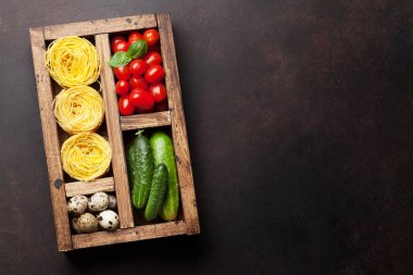 Makarna ve malzemeler. Domates, fesleğen, salatalık. Pişirme kavramı. Metin alanı olan üstten görünüm