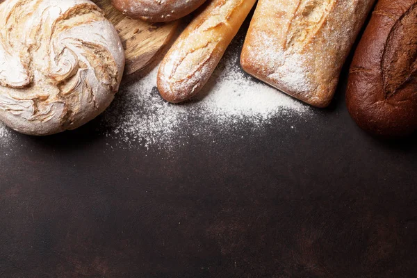 Διάφορα Ξεροψημένο Ψωμί Και Ψωμάκια Στο Πέτρινο Τραπέζι Top View — Φωτογραφία Αρχείου