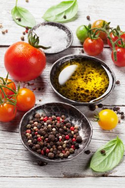 Domates, fesleğen, zeytinyağı ve baharat ahşap masa üzerinde. Pişirme kavramı