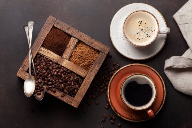 Kahve bardakları, kavrulmuş fasulye ve çekilmiş kahve. Üstten görünüm