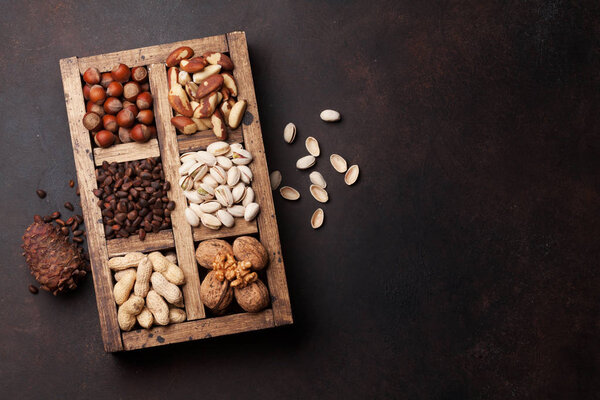 Various nuts selection: peanuts, hazelnuts, chestnuts, walnuts, pistachios and pecans in wooden box. Top view with space for your text