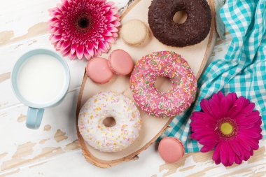 Süt, çörek ve ahşap masaya çiçek. Üstten Görünüm