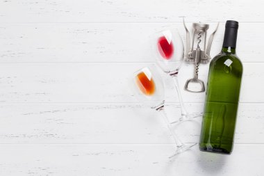 Şarap şişe ve bardak beyaz tahta masada. Metin alanı olan üstten görünüm