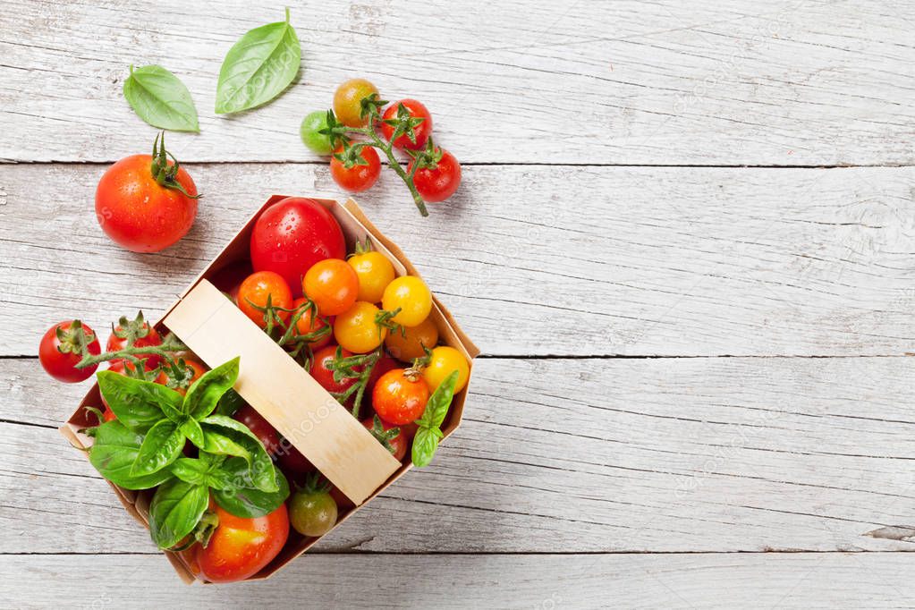 Various colorful tomatoes on wooden table. Top view with space for your text