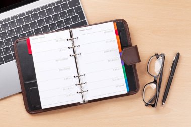 Ofis İşyeri masası Not defteri ve dizüstü bilgisayar ile. Düz yatıyordu. Metin alanı olan üstten görünüm
