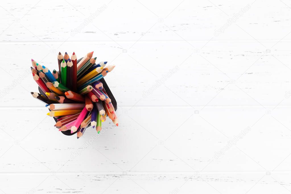 Colorful pencils on white wooden table. Top view with copy space 