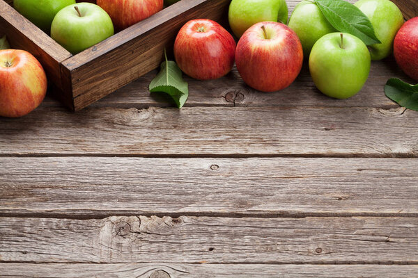 Спелые зеленые и красные яблоки на деревянном столе. С пространством для вашего текста
