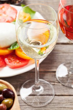 Gül ve beyaz şarap gözlük caprese salatası ile. Geleneksel İtalyan antipasti