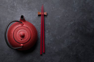 Kırmızı çay pot ve suşi yemek çubukları. Üstten görünüm sizin metin için yer ile. Düz yatıyordu