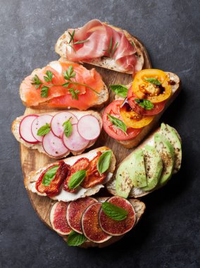 Brushetta veya geleneksel İspanyolca tapas. Meze İtalyan antipasti aperatifler ahşap tahta üzerinde ayarlayın. Üstten görünüm ve düz lay