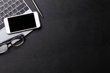 Ofis siyah masası malzemeleri, smartphone ve dizüstü bilgisayar ile. Düz yatıyordu. Metin alanı olan üstten görünüm