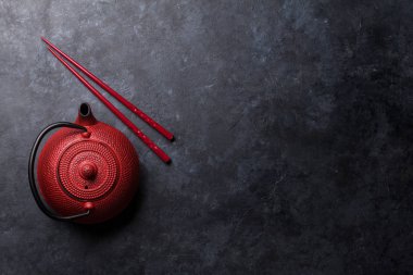 Kırmızı çay pot ve suşi yemek çubukları. Kopya alanı ile üstten görünüm