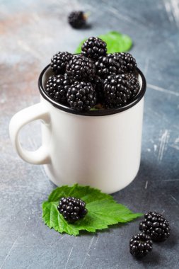 Taş masada olgun böğürtlen fincan