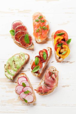 Brushetta veya geleneksel İspanyolca tapas. Meze İtalyan antipasti aperatifler ahşap tahta üzerinde ayarlayın. Üstten görünüm ve düz lay
