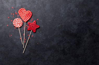 Renkli tatlılar. Lolipop ve şeker koyu arka plan üzerinde. Kopya alanı ile üstten görünüm