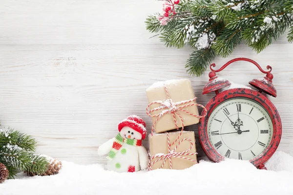 クリスマス ギフト ボックス 目覚まし時計 木製の壁の前に雪で覆われてモミの木の枝 あなたの挨拶のコピー スペース — ストック写真