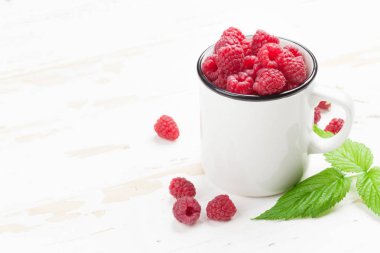 Ahşap masa üzerinde olgunlaşmış ahududu fincan. Senin metin için ile yer