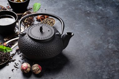 Çeşitli çay ve çaydanlık kopya alanı karanlık taş zemin üzerine Kazanlı
