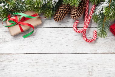 Kar köknar ağacı, hediye kutusu ve şeker ile Noel arka plan üzerinde ahşap masa köpekler. Selam yeri olan üstten görünüm