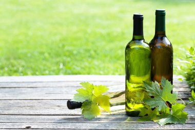 Ahşap masa üzerinde beyaz şarap şişeleri. Açık natürmort. Senin metin için ile yer