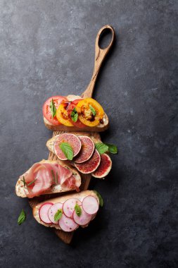 Brushetta veya geleneksel İspanyolca tapas. Meze İtalyan antipasti aperatifler ahşap tahta üzerinde ayarlayın. Üstten görünüm ve düz lay kopya alanı ile