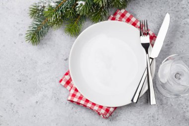 Taş zemin üzerine kar tarafından Noel tablo ayarını köknar ağacı dalı ile kaplı. Boş tabak, çatal ve bıçak. Selam yeri olan üstten görünüm