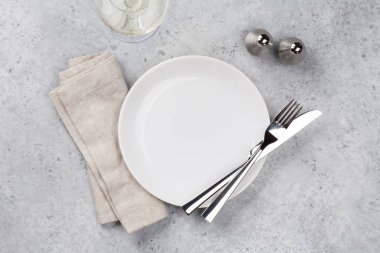 Tablo ayarı. Boş levha, bıçak, çatal, şarap kadehi ve peçete. Üstten görünüm ve düz lay kopya alanı ile