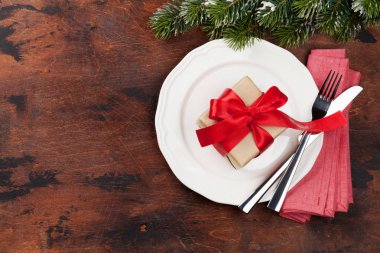 Ahşap arka plan üzerinde kar tarafından Noel tablo ayarını hediye kutusu ve köknar ağacı dalı ile kaplı. Selam yeri olan üstten görünüm