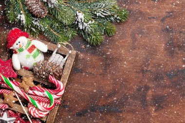 Noel dekor kutu ve köknar ahşap arka plan üzerinde kar kapsamında şube ağaç. Üstten görünüm xmas zemin alan selam ile