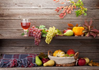 Sonbahar natürmort kartıyla kabaklar, üzüm, elma, armut, şarap ve renkli ahşap duvarın önünde bırakır. Senin metin için ile yer