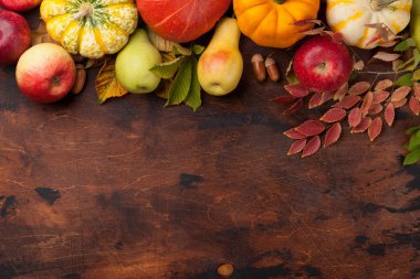 Sonbahar zemin kabak, elma, armut ve ahşap arka plan üzerinde renkli yaprakları ile. Metin alanı olan üstten görünüm