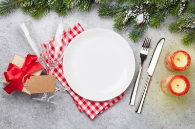 Taş zemin üzerine kar tarafından Noel tablo ayarını şampanya, hediye kutusu ve köknar ağacı dalı ile kaplı. Selam yeri olan üstten görünüm