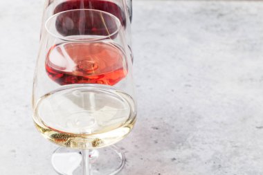 Kırmızı, gül ve beyaz şarap bardakları taş zemin üzerinde. Senin metin için ile yer